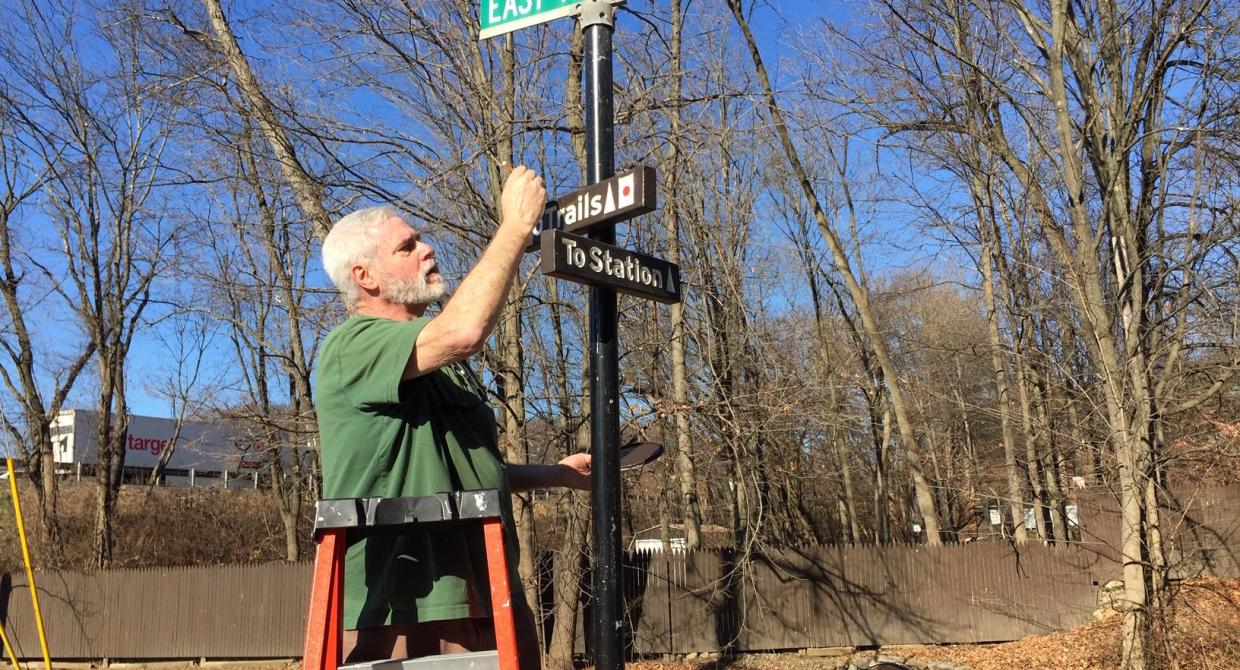 Trail Conference Volunteer installing new signs in Tuxedo, N.Y.