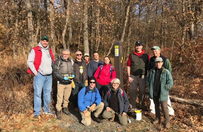 Proud volunteers pose by a new Lenape Trail sign bollard.